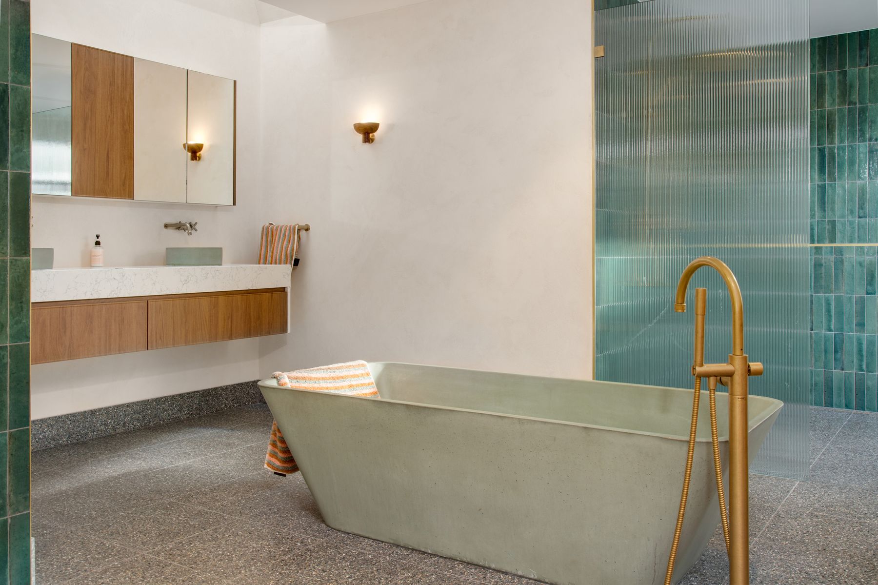 A resolved wet area: freestanding bath, tiled walls and considered tapware in a completed bathroom